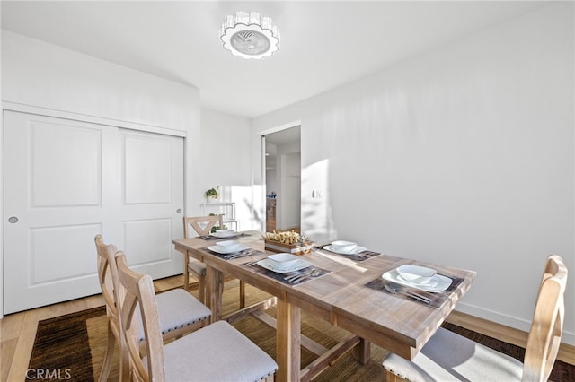 dining area featuring light wood-style floors and baseboards