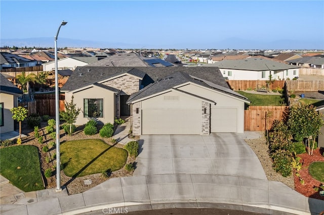 single story home with a residential view, an attached garage, driveway, and fence