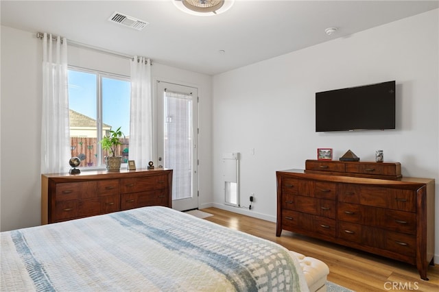 bedroom featuring baseboards, visible vents, and light wood finished floors