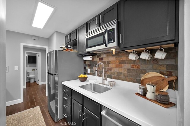 100 Atlantic Ave Unit 205, Long Beach, CA 90802 - kitchen featuring appliances with stainless steel finishes, a sink, decorative backsplash, baseboards, and wood tiled floors
