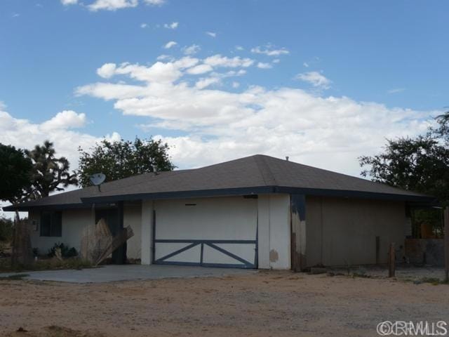 view of front facade featuring stucco siding, driveway, and a garage