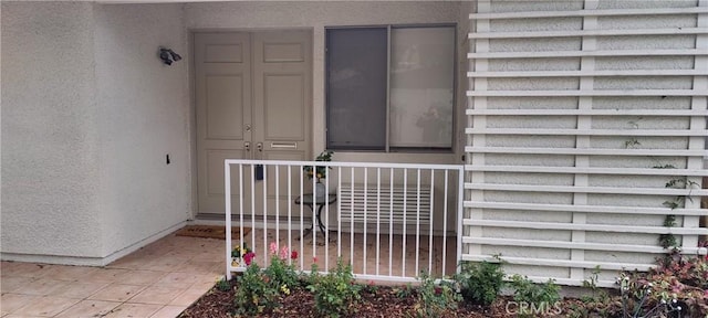 doorway to property featuring stucco siding