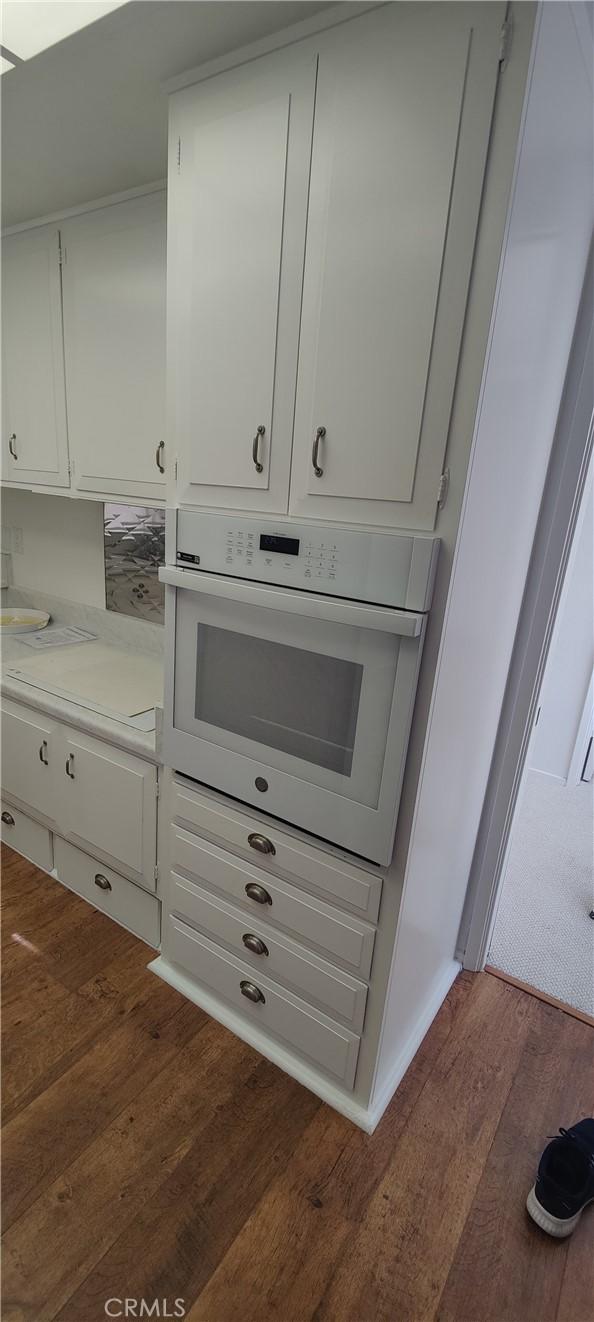 room details with white oven and wood finished floors