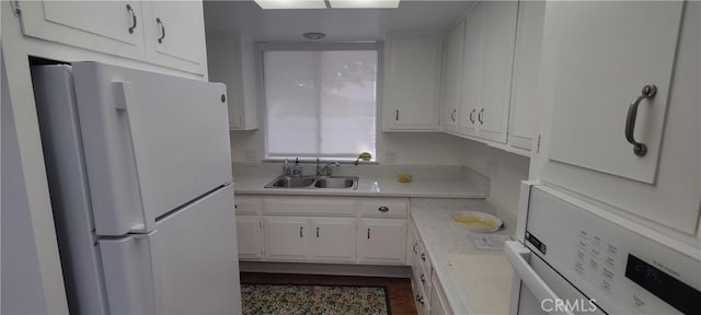 kitchen featuring white cabinetry, freestanding refrigerator, light countertops, and a sink