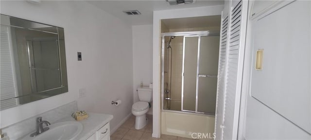 bathroom featuring visible vents, toilet, tile patterned floors, combined bath / shower with glass door, and vanity