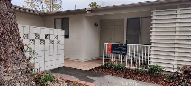 property entrance with stucco siding