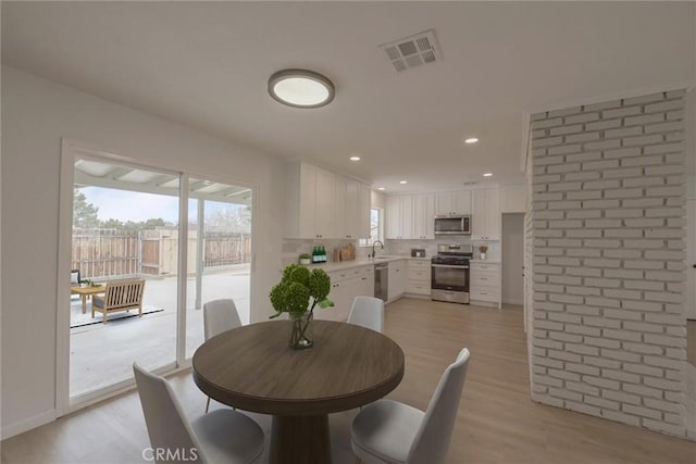 dining room featuring baseboards, recessed lighting, visible vents, and light wood-type flooring