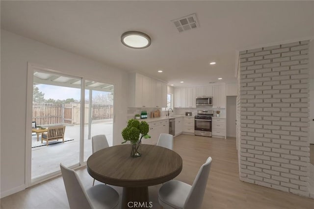 dining space featuring recessed lighting, visible vents, and light wood-type flooring