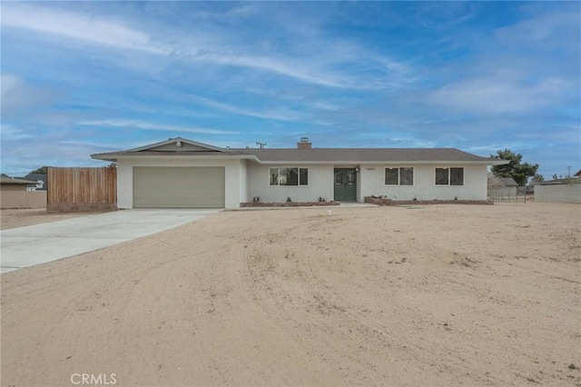 ranch-style house with an attached garage, driveway, stucco siding, and fence