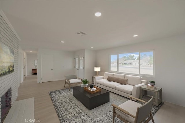living room with visible vents, light wood-type flooring, recessed lighting, and a fireplace