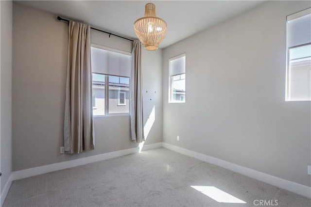 carpeted spare room featuring baseboards