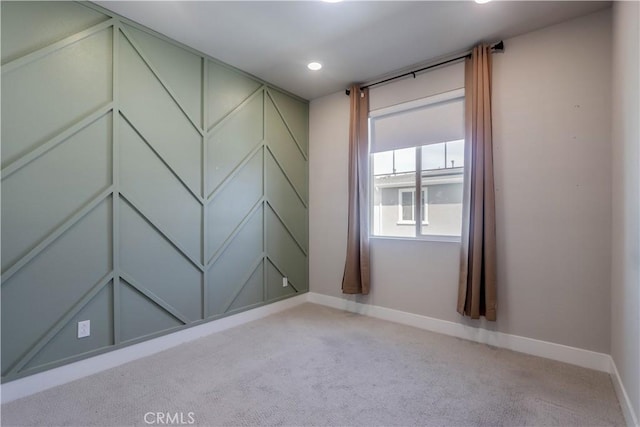 spare room featuring recessed lighting, baseboards, and light carpet