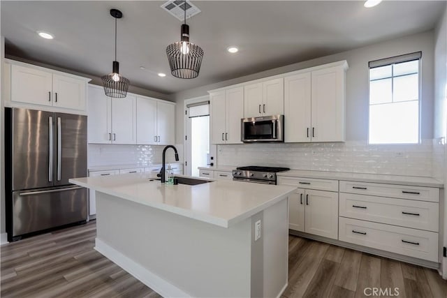 kitchen with visible vents, a sink, white cabinetry, appliances with stainless steel finishes, and light countertops