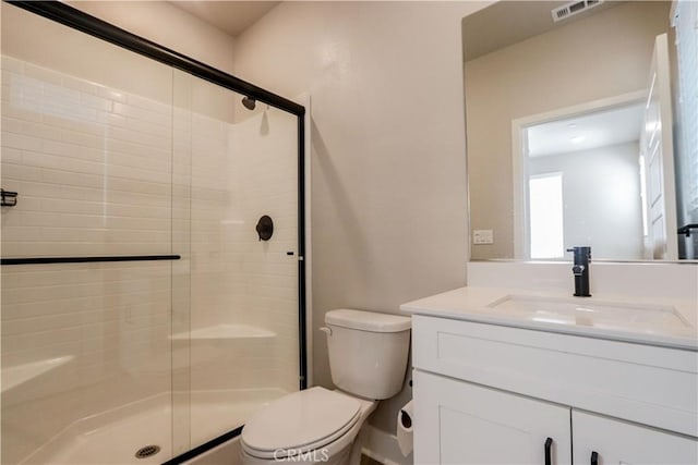 bathroom featuring vanity, a shower stall, toilet, and visible vents