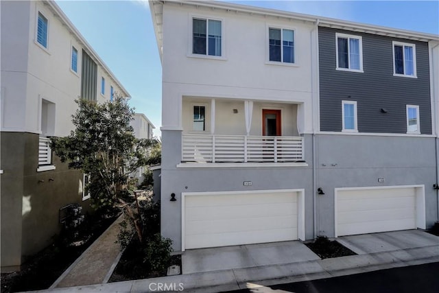 view of front of home featuring stucco siding, a balcony, concrete driveway, and an attached garage