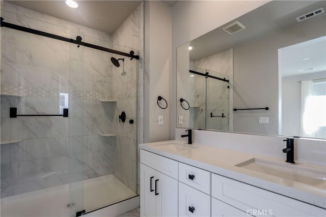 full bathroom featuring a sink, visible vents, a marble finish shower, and double vanity