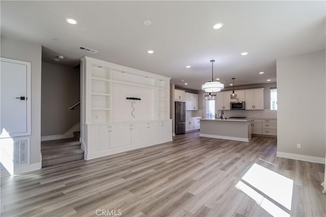 unfurnished living room with recessed lighting, visible vents, and light wood finished floors