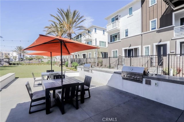 view of patio / terrace featuring area for grilling, outdoor dining space, exterior kitchen, and fence