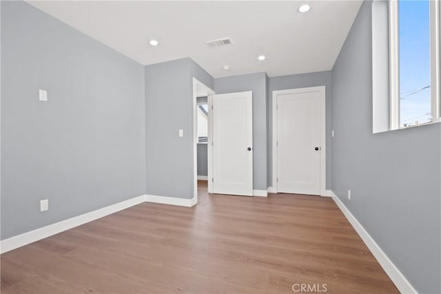 interior space featuring recessed lighting, wood finished floors, visible vents, and baseboards