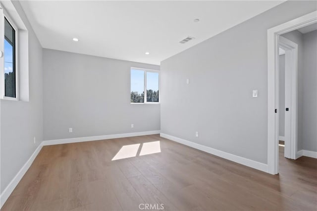 unfurnished room featuring recessed lighting, visible vents, baseboards, and wood finished floors