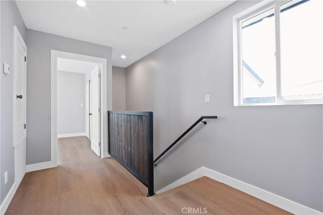 corridor featuring an upstairs landing, recessed lighting, light wood finished floors, and baseboards