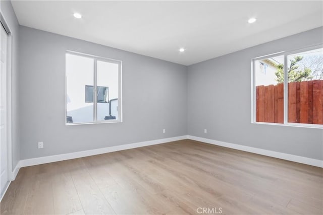 empty room featuring recessed lighting, baseboards, and wood finished floors