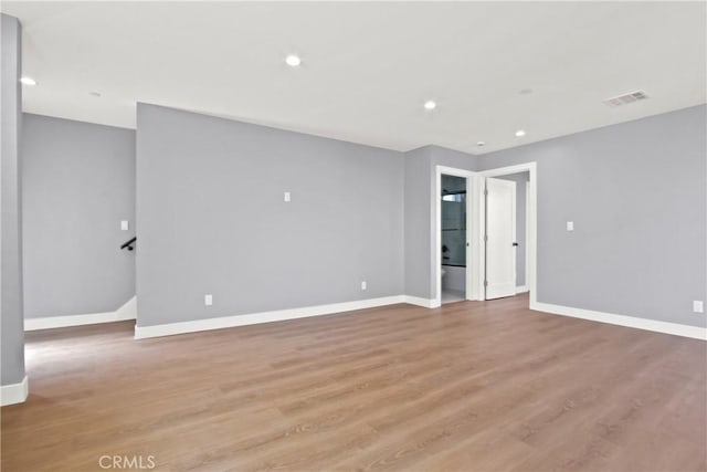 empty room with light wood-style flooring, recessed lighting, baseboards, and visible vents