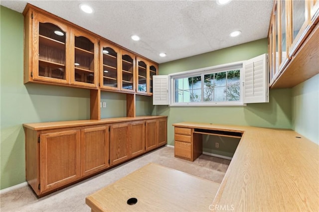 unfurnished office featuring recessed lighting, light colored carpet, a textured ceiling, and built in study area