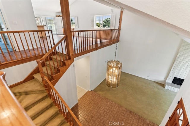 stairway featuring high vaulted ceiling and carpet flooring