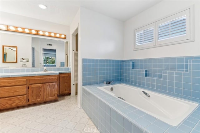 bathroom featuring vanity, a garden tub, tile patterned floors, and a wealth of natural light