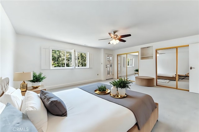 bedroom with a ceiling fan, baseboards, and two closets