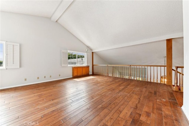 additional living space featuring lofted ceiling with beams, baseboards, and hardwood / wood-style flooring