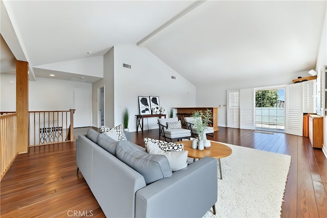 living area featuring visible vents, beamed ceiling, high vaulted ceiling, and hardwood / wood-style flooring