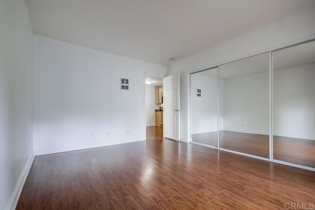 unfurnished bedroom featuring a closet and wood finished floors