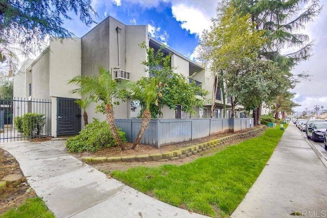 view of property exterior with fence and stucco siding