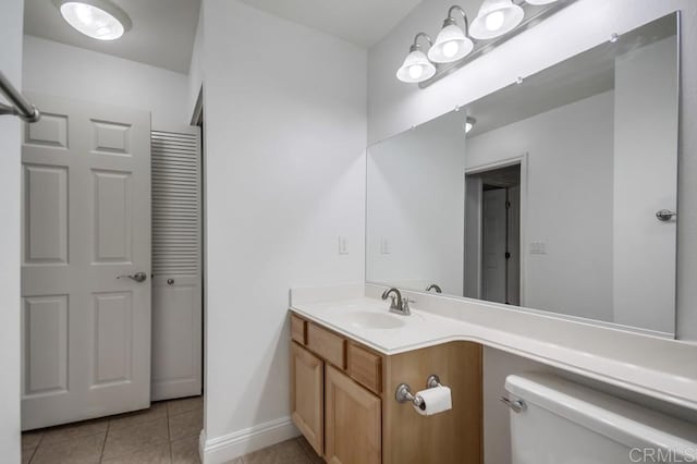 bathroom featuring vanity, tile patterned floors, toilet, and baseboards