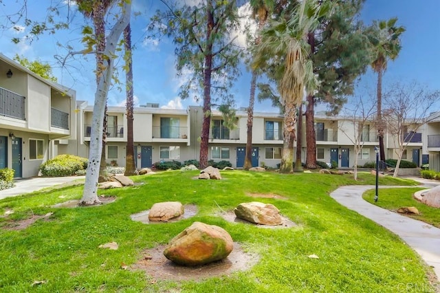 view of home's community featuring a lawn and a residential view