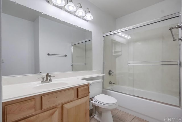 bathroom with tile patterned floors, combined bath / shower with glass door, toilet, and vanity