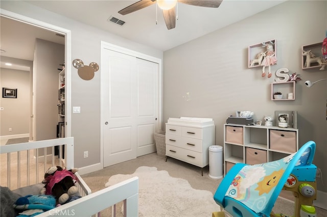 bedroom with a closet, visible vents, light carpet, and ceiling fan