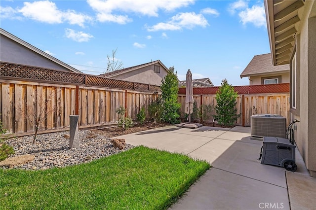 view of yard featuring a patio area, central air condition unit, and a fenced backyard