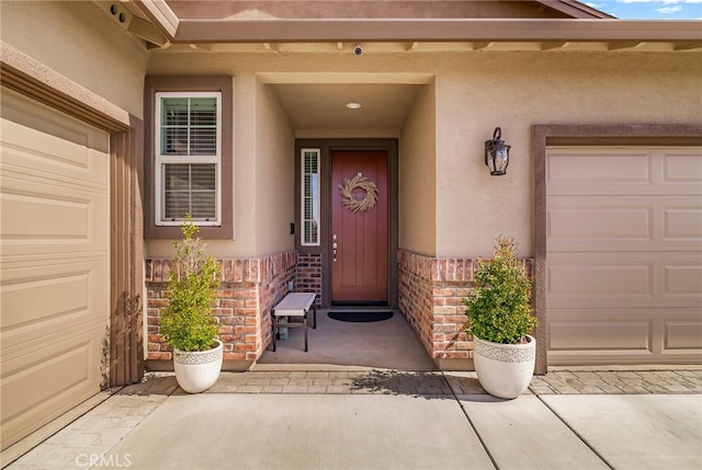 entrance to property with a garage and stucco siding