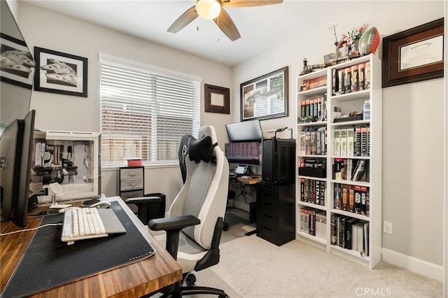 carpeted office space with baseboards and ceiling fan