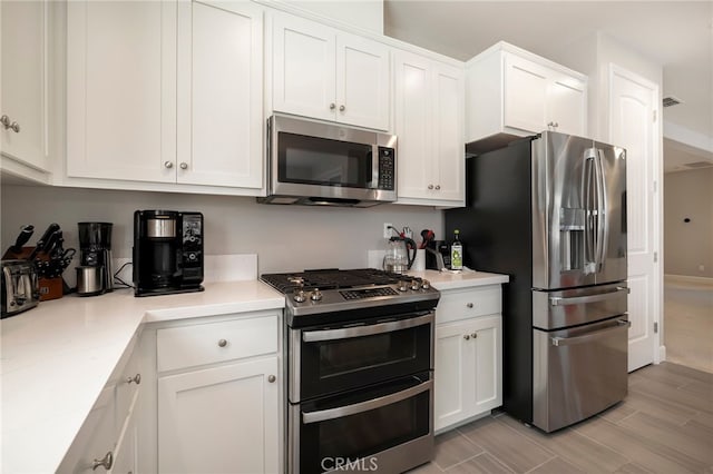 kitchen with visible vents, appliances with stainless steel finishes, light countertops, and white cabinetry