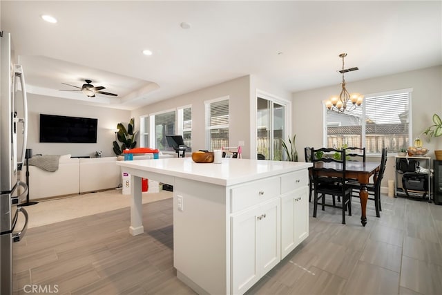 kitchen featuring a wealth of natural light, white cabinets, open floor plan, and freestanding refrigerator