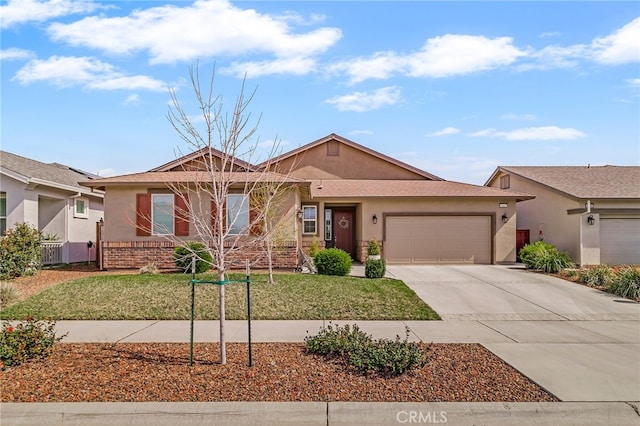 ranch-style house featuring stucco siding, a front lawn, concrete driveway, an attached garage, and brick siding