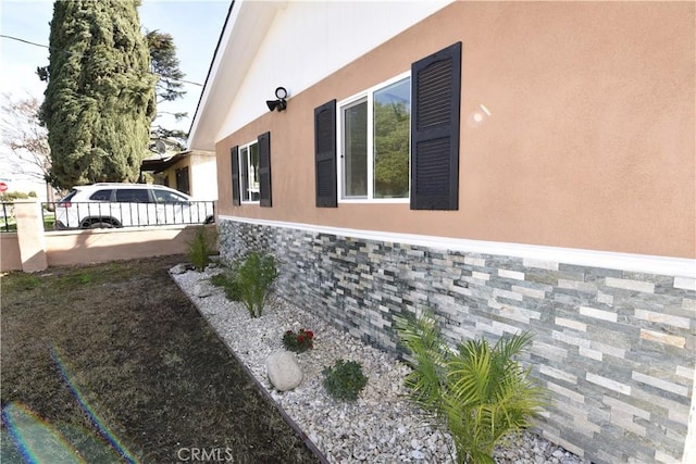 14730 Clark St, Baldwin Park, CA 91706 - view of property exterior with stone siding, stucco siding, and fence
