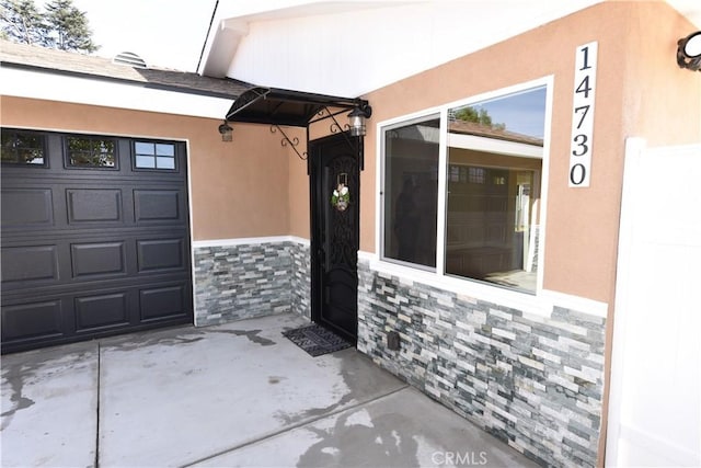14730 Clark St, Baldwin Park, CA 91706 - property entrance featuring stone siding, stucco siding, and a garage