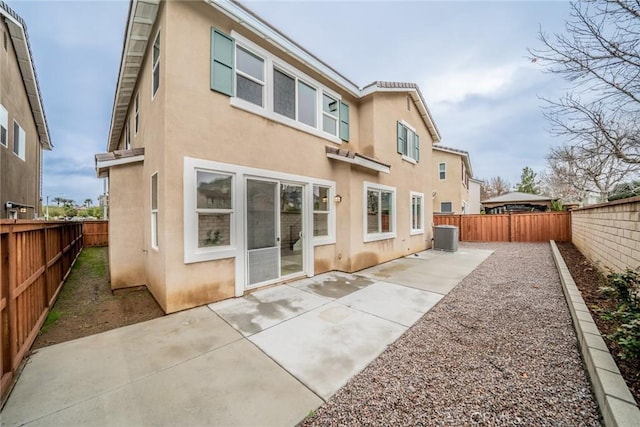 back of house with stucco siding, a patio, a fenced backyard, and central air condition unit