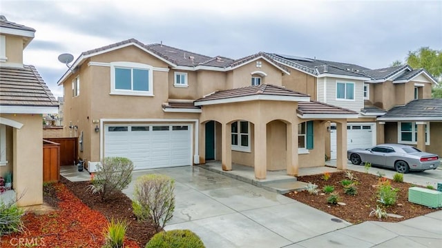 view of front of home featuring stucco siding, driveway, an attached garage, and a tiled roof