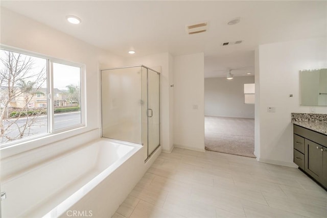 bathroom with a garden tub, recessed lighting, a shower stall, baseboards, and vanity